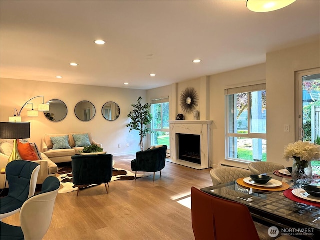 living area featuring recessed lighting, light wood-style flooring, and a fireplace