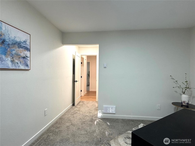 unfurnished bedroom featuring baseboards, carpet flooring, and visible vents