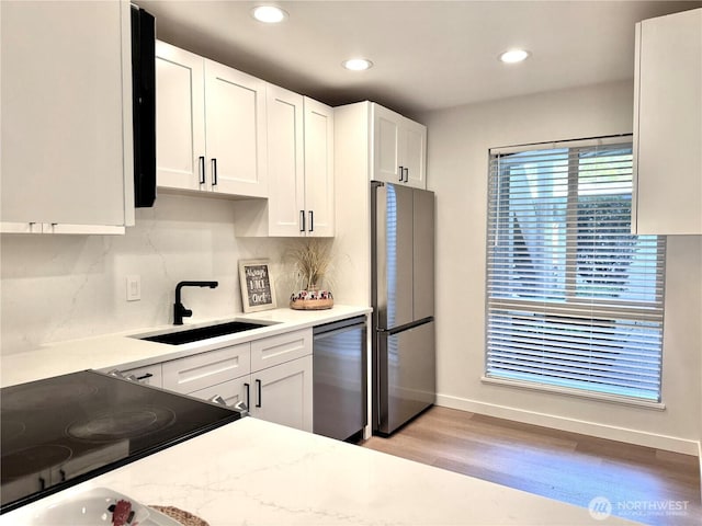 10221 NE 16th St Unit H5, Bellevue, WA 98004 - kitchen featuring white cabinets, appliances with stainless steel finishes, a sink, baseboards, and light wood-type flooring