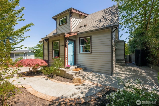 view of front of property with fence and roof with shingles