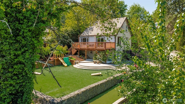 rear view of house featuring a wooden deck, a yard, stairway, and a playground