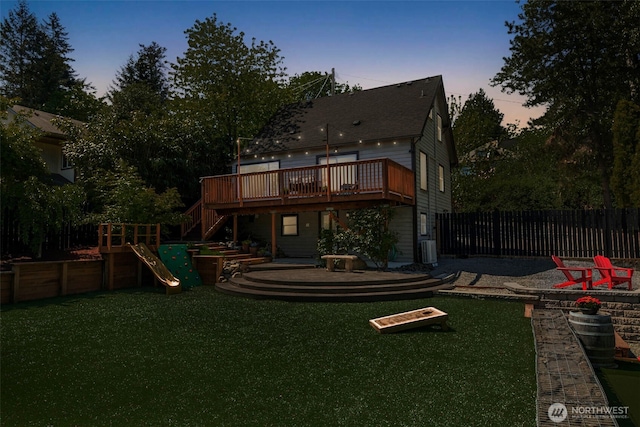 back of house with a wooden deck, stairway, central AC unit, a playground, and a shingled roof