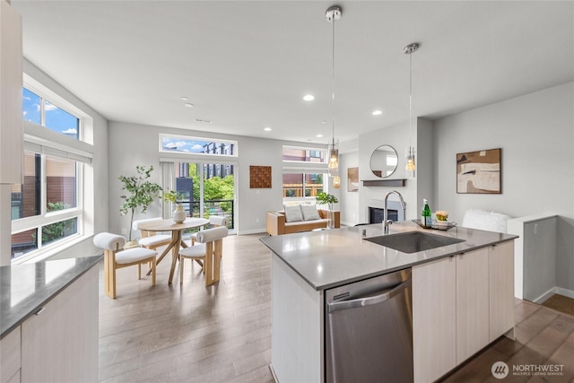 2055 NW Talus Dr Unit 3, Issaquah, WA 98027 - kitchen with stainless steel dishwasher, a sink, modern cabinets, light wood-style floors, and a center island with sink