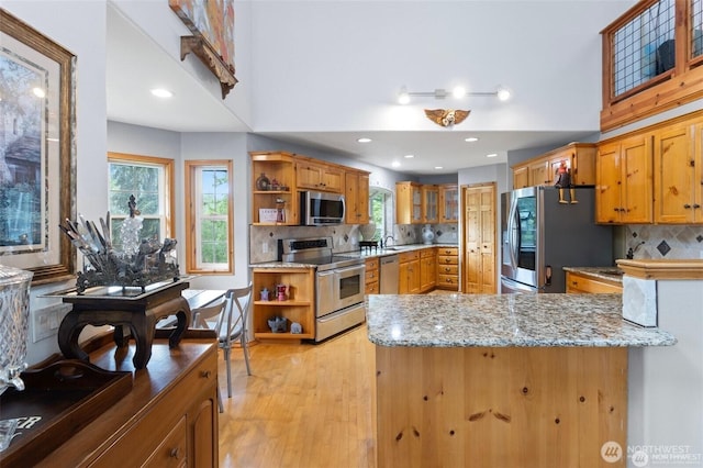 17613 Butler Rd, Snohomish, WA 98290 - kitchen with stainless steel appliances, open shelves, light stone countertops, a peninsula, and backsplash