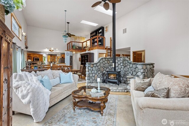 17613 Butler Rd, Snohomish, WA 98290 - living area with ceiling fan, a high ceiling, a wood stove, and tile patterned flooring