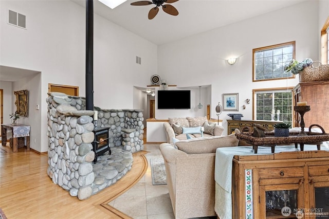 17613 Butler Rd, Snohomish, WA 98290 - living area with high vaulted ceiling, ceiling fan, a wood stove, and wood finished floors