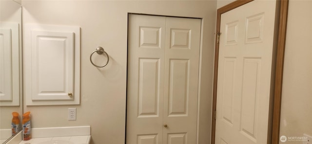 bathroom with a closet and vanity