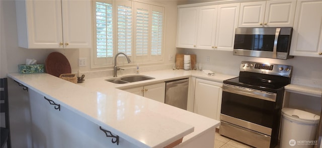 kitchen featuring white cabinets, appliances with stainless steel finishes, a sink, and light countertops