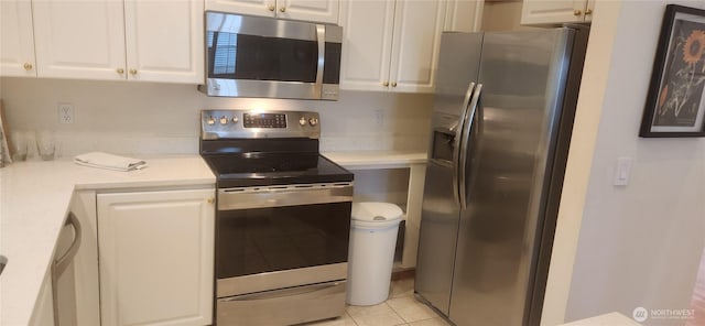 kitchen featuring light countertops, light tile patterned floors, stainless steel appliances, and white cabinetry