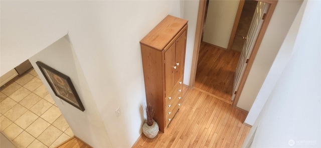 hall with baseboards and light wood finished floors