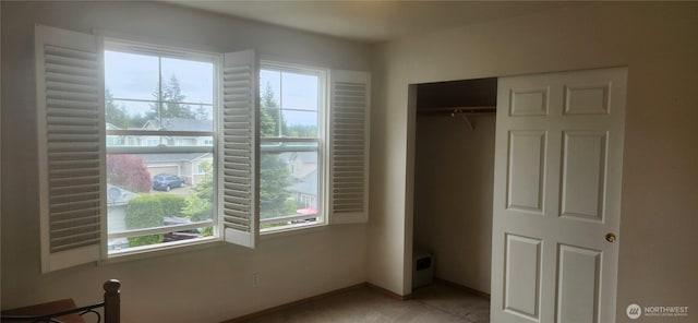 unfurnished bedroom featuring baseboards and a closet