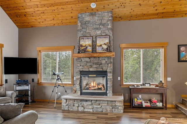living room featuring lofted ceiling, wooden ceiling, baseboards, wood finished floors, and a fireplace