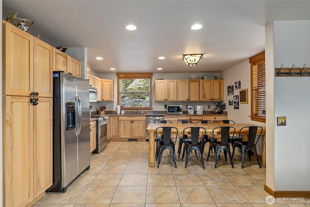 kitchen featuring a sink, recessed lighting, light brown cabinetry, light tile patterned floors, and appliances with stainless steel finishes