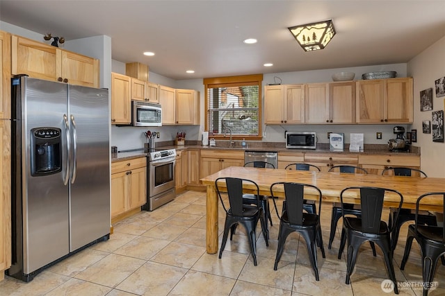 kitchen with light brown cabinets, recessed lighting, light tile patterned flooring, a sink, and stainless steel appliances