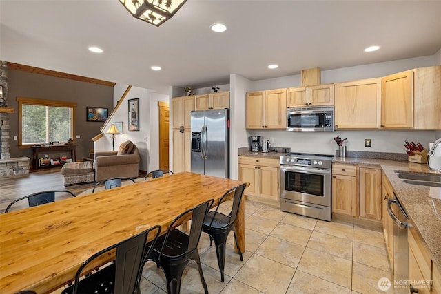 kitchen with light tile patterned floors, a sink, light brown cabinetry, appliances with stainless steel finishes, and recessed lighting