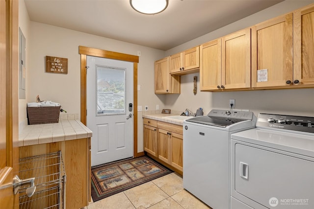 washroom featuring a sink, separate washer and dryer, cabinet space, and light tile patterned floors