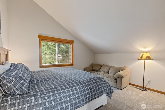 carpeted bedroom featuring lofted ceiling and baseboards