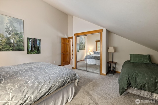 carpeted bedroom featuring lofted ceiling, baseboards, and a closet