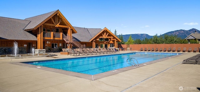 community pool with a mountain view, a patio, and stairs