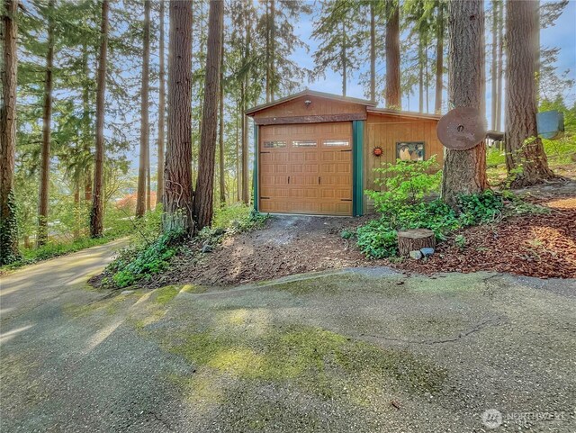 view of outbuilding featuring aphalt driveway and an outbuilding