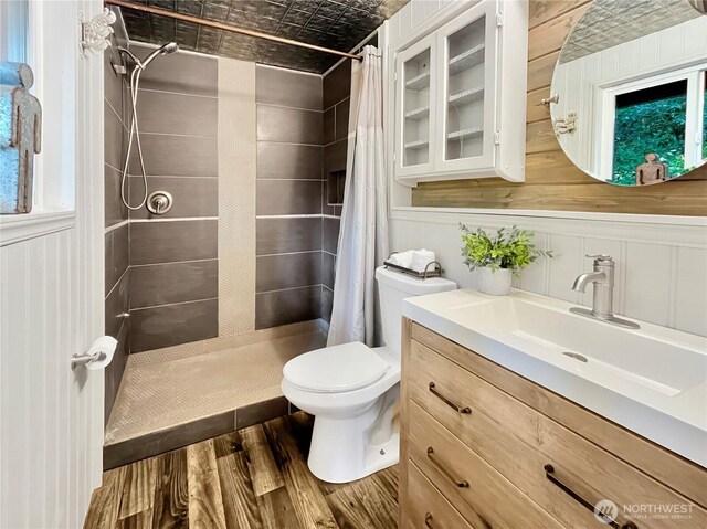 full bath featuring vanity, a stall shower, toilet, and wood finished floors