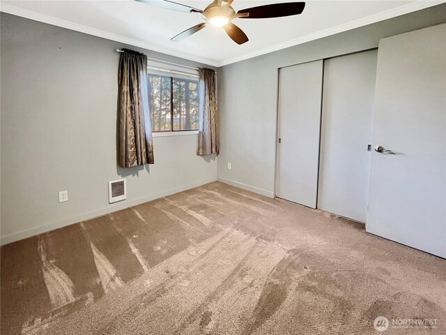 unfurnished bedroom with crown molding, visible vents, baseboards, ceiling fan, and carpet flooring
