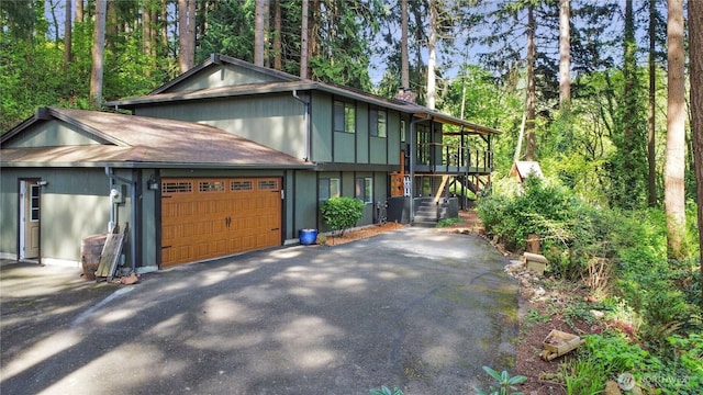 view of front facade featuring stairs, a garage, and driveway