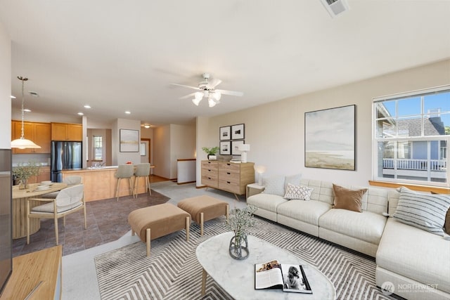 living room with a ceiling fan, recessed lighting, and visible vents
