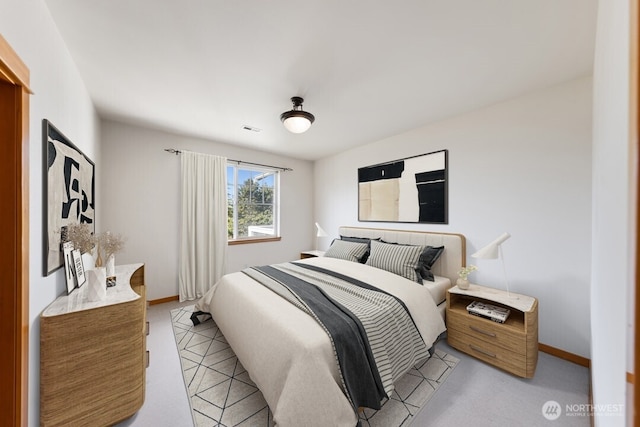 bedroom with baseboards, visible vents, and light carpet