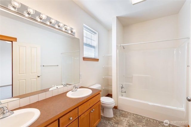 full bath with double vanity, a sink, shower / bath combination, and toilet