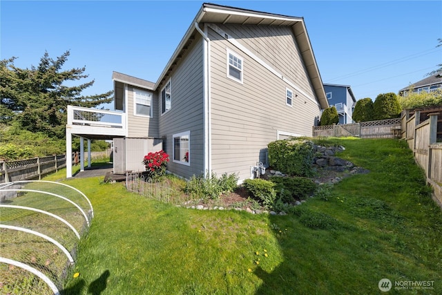 back of property with fence, a yard, and a deck