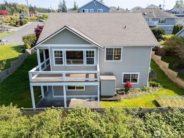 back of house featuring a fenced backyard, a wooden deck, and roof with shingles