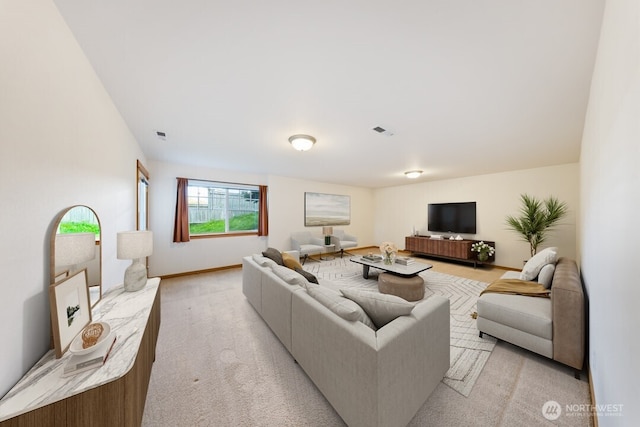 living area featuring light colored carpet, baseboards, and visible vents