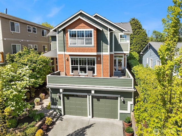 view of front facade featuring an attached garage, a balcony, and driveway