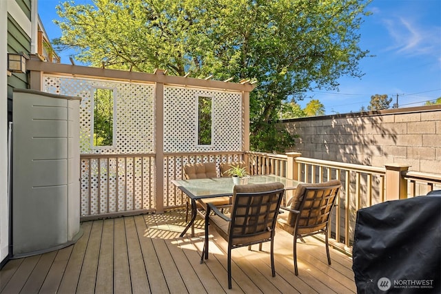 wooden terrace featuring a grill and outdoor dining space