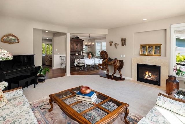 carpeted living room with a premium fireplace, an inviting chandelier, plenty of natural light, and recessed lighting