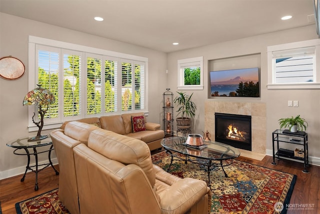 living area featuring baseboards, recessed lighting, and a fireplace