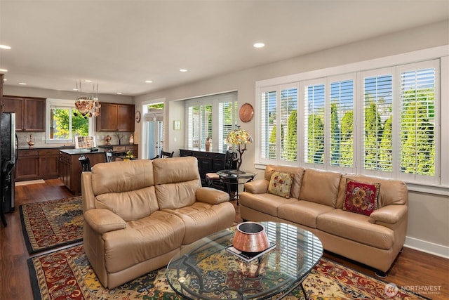 living room featuring dark wood-type flooring, recessed lighting, and baseboards
