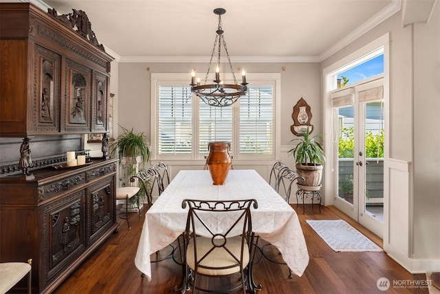 dining area with ornamental molding, dark wood finished floors, and a notable chandelier
