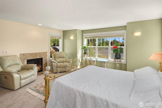 bedroom featuring carpet floors and a tiled fireplace