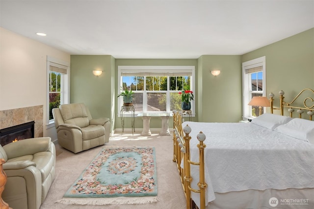 carpeted bedroom with recessed lighting, baseboards, and a glass covered fireplace