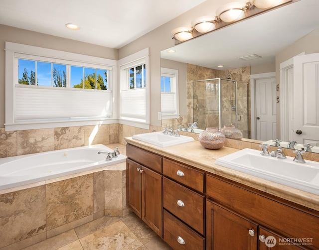 full bath with a garden tub, a sink, double vanity, and a shower stall