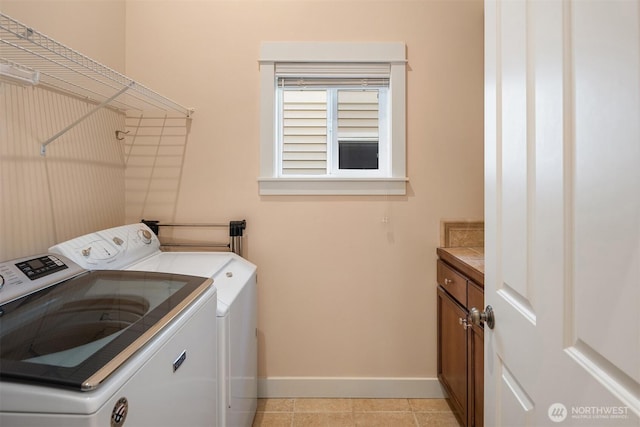 clothes washing area featuring washer and dryer, light tile patterned flooring, baseboards, and cabinet space