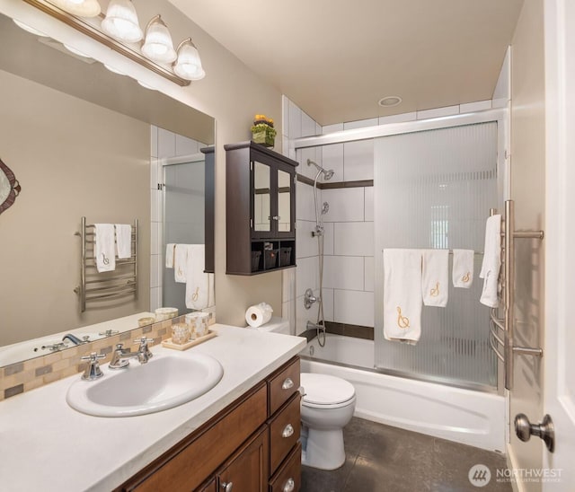 bathroom featuring vanity, tile patterned floors, combined bath / shower with glass door, and toilet