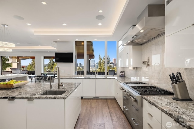 209 Northside Rd, Bellevue, WA 98004 - kitchen featuring wall chimney range hood, stainless steel gas cooktop, a sink, white cabinets, and recessed lighting