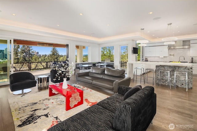 209 Northside Rd, Bellevue, WA 98004 - living room featuring healthy amount of natural light, a raised ceiling, light wood-type flooring, recessed lighting, and a chandelier