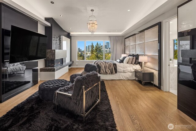 209 Northside Rd, Bellevue, WA 98004 - bedroom featuring light wood-style flooring, a multi sided fireplace, recessed lighting, a chandelier, and baseboards