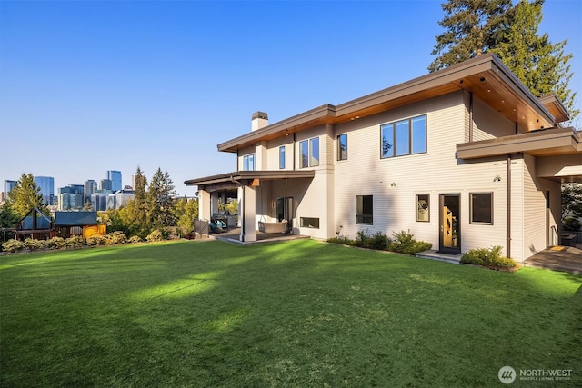 209 Northside Rd, Bellevue, WA 98004 - back of house featuring a chimney, a lawn, and a patio area