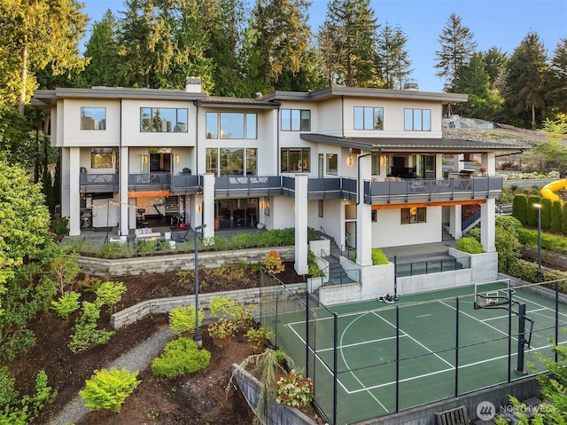 209 Northside Rd, Bellevue, WA 98004 - rear view of property featuring a tennis court, fence, stucco siding, and a chimney