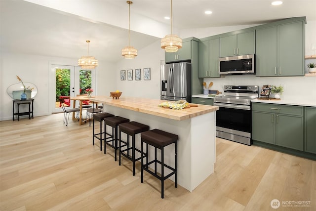 kitchen featuring stainless steel appliances, wood counters, light wood finished floors, and green cabinets